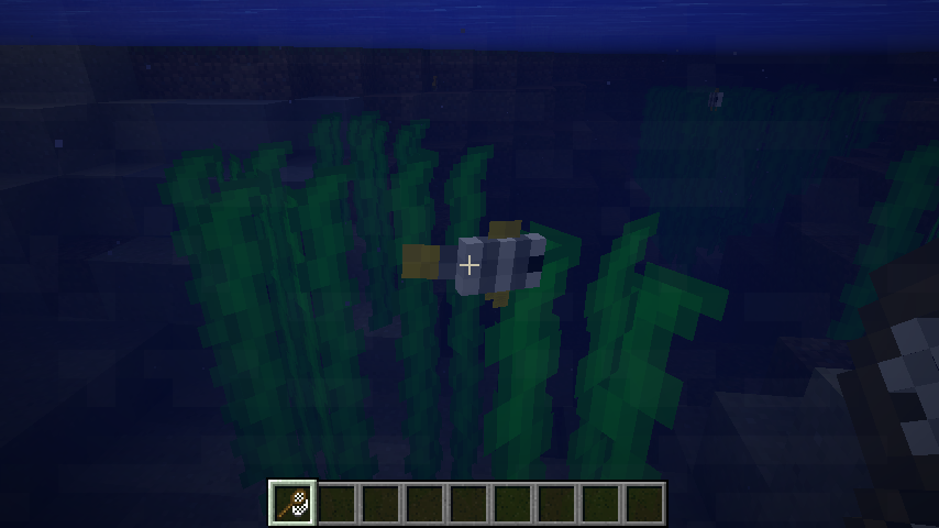 A moorish idol swimming through kelp